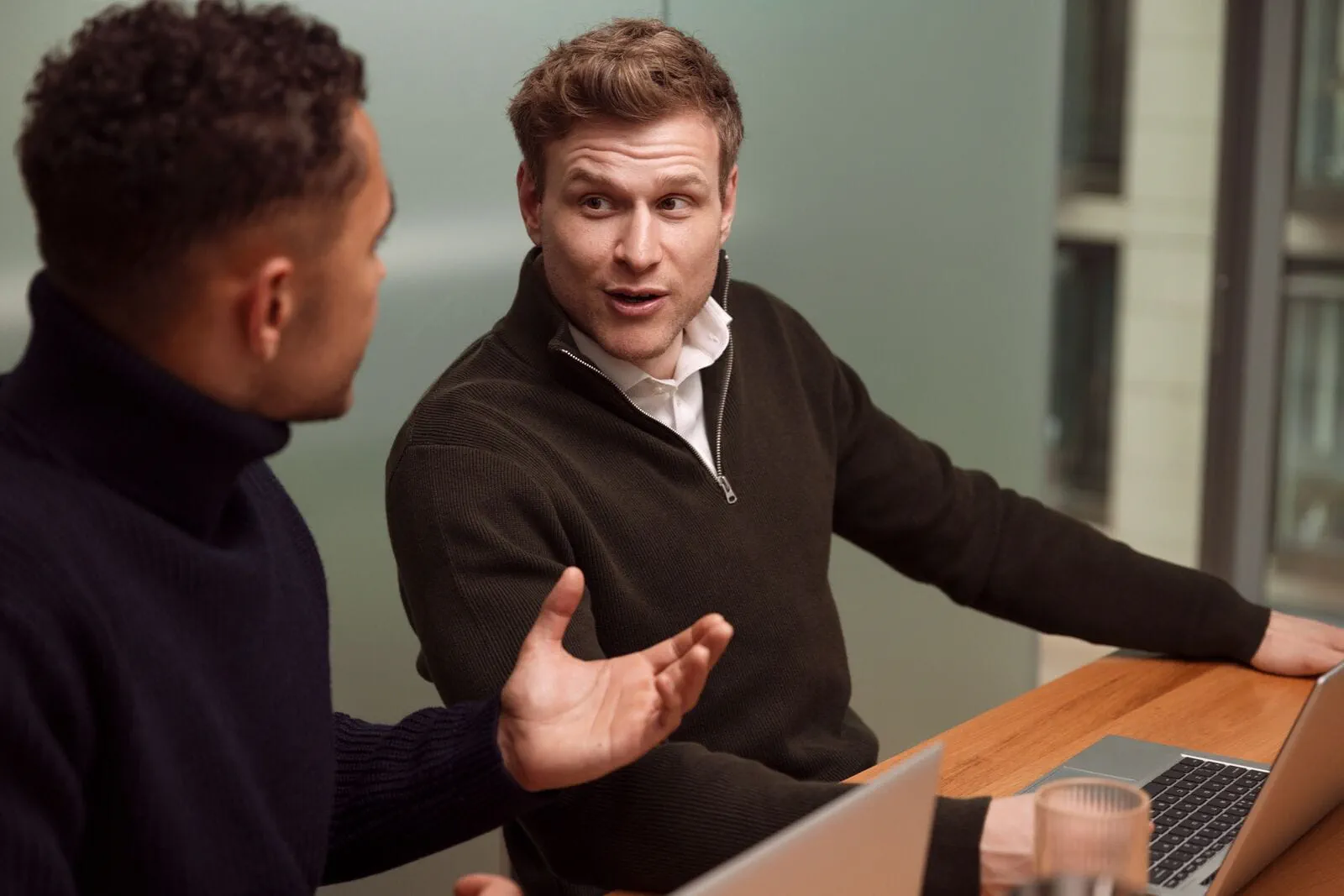 Deux professionnels assis en discussion, illustrant la compréhension et la mise en œuvre de la RSE en entreprise Deux professionnels assis en discussion, illustrant la compréhension et la mise en œuvre de la RSE en entreprise