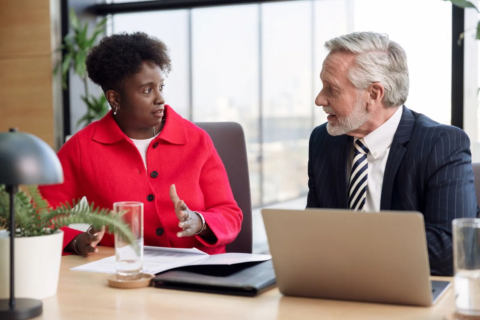 Discussion entre deux cadres en entreprise symbolisant la mise en place d’une stratégie efficace pour fidéliser les talents