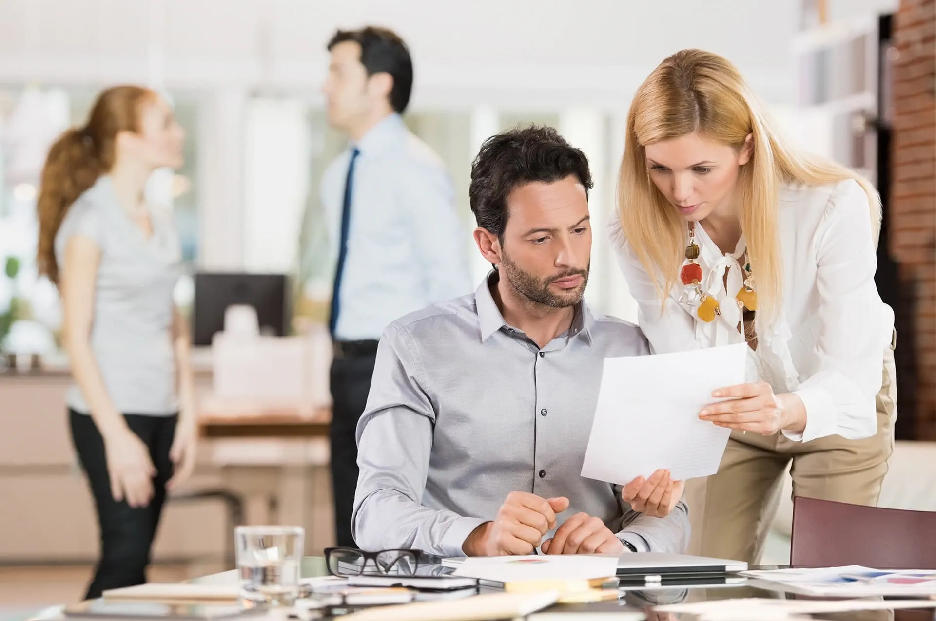 man-and-woman-discussing-document-in-office-lhh man-and-woman-discussing-document-in-office-lhh