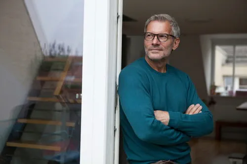 50+ man leaning on a doorframe 50+ man leaning on a doorframe