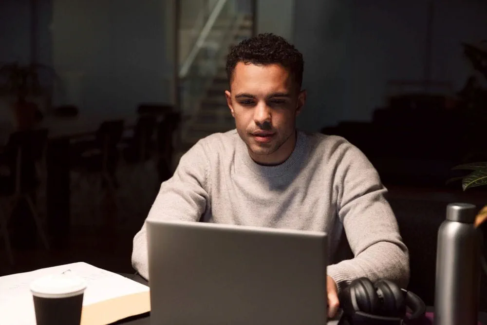Un candidat vérifiant une annonce d’emploi en ligne sur son ordinateur portable pour éviter une fraude Un candidat vérifiant une annonce d’emploi en ligne sur son ordinateur portable pour éviter une fraude