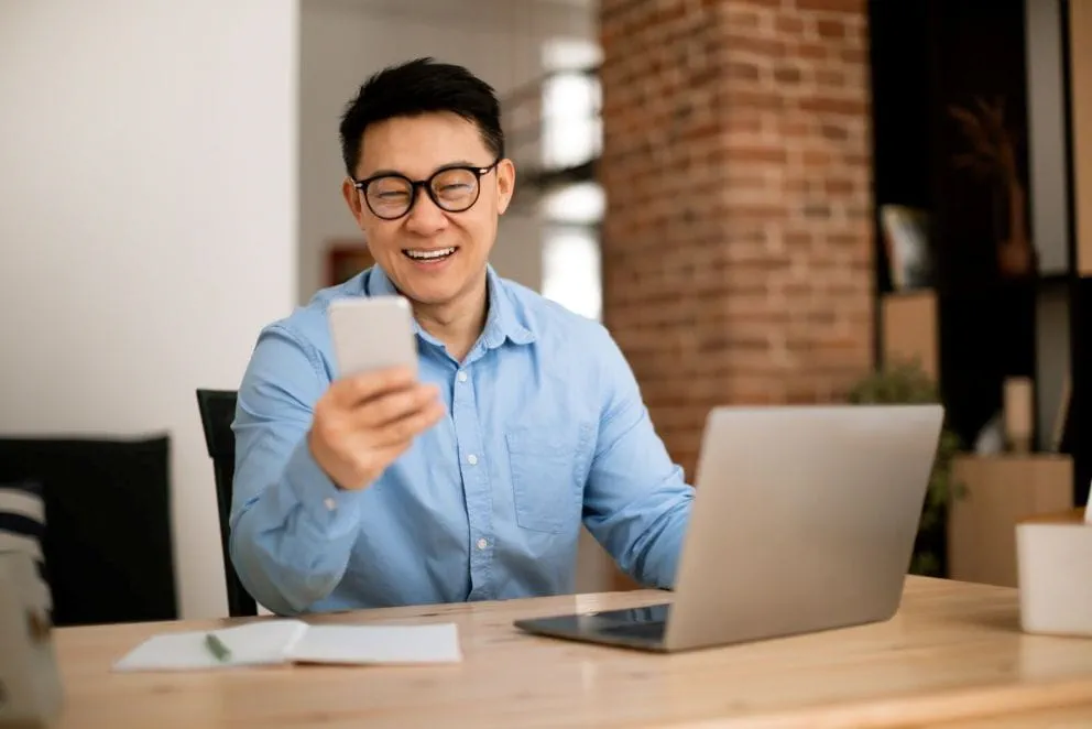 Un candidat à son bureau échangeant avec son réseau via les réseaux sociaux professionnels Un candidat à son bureau échangeant avec son réseau via les réseaux sociaux professionnels