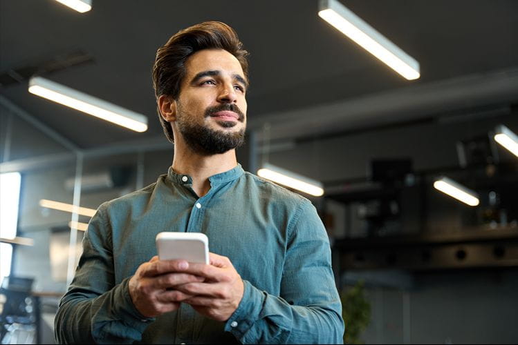 Homme consultant son téléphone pour gérer sa carrière à l’ère de l’intelligence artificielle