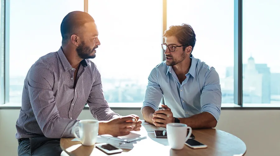 Business-partners-discussing-business-plans-sitting-at-table-in-office