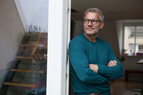 50+ man leaning on a doorframe