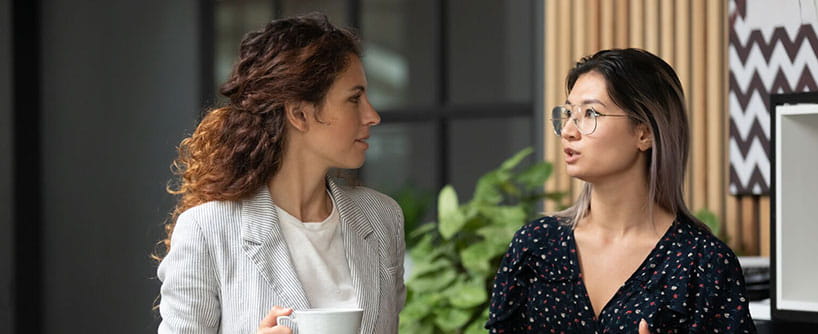 Deux professionnelles marchant et parlant d’un plan de carrière professionnelle.