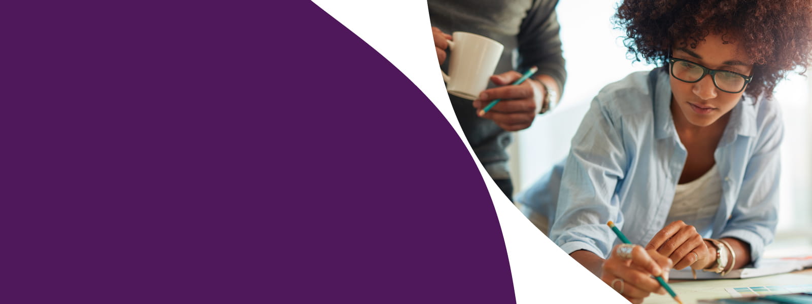 Une collaboratrice travaillant sur un projet technique à son bureau, guidée par un spécialiste en ingénierie.