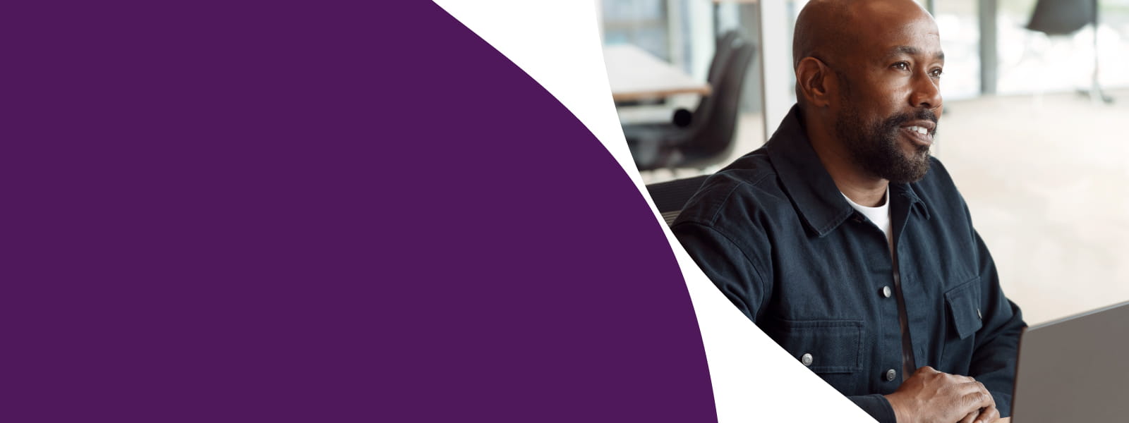 Homme assis à son bureau, écoutant un collègue lors d’un échange sur des projets IT et télécoms