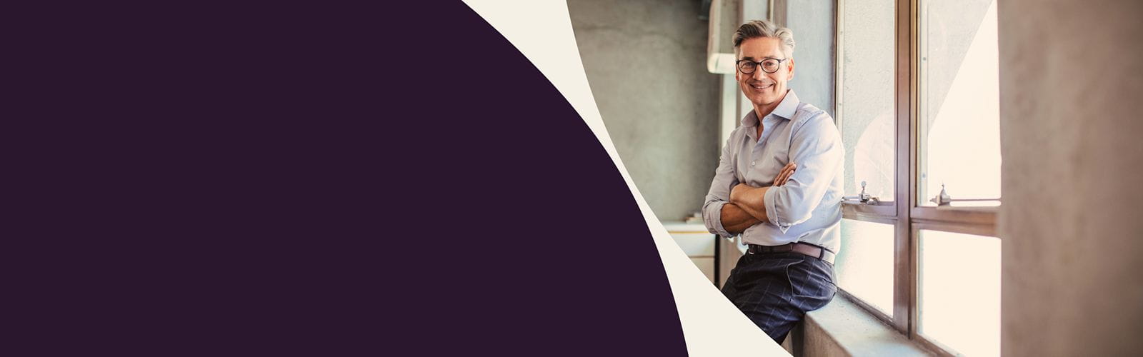 Bannière de présentation : un homme bras croisés est assis sur un rebord de fenêtre