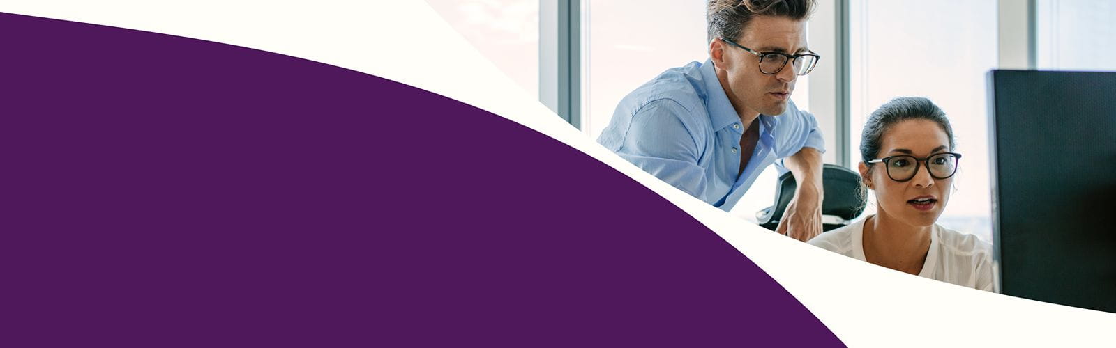 Bannière de présentation : un homme et un femme regardent un ordinateur