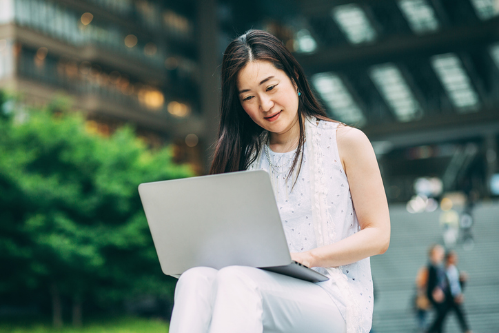 woman sitting outside working on laptop