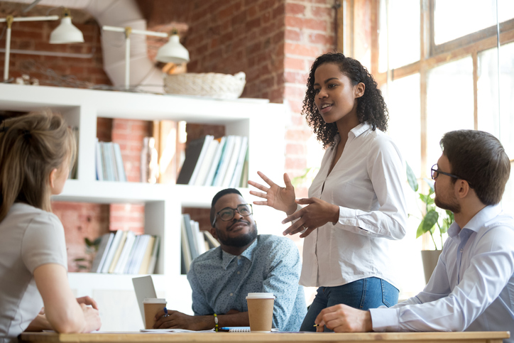 smart female employee speaking at diverse meeting