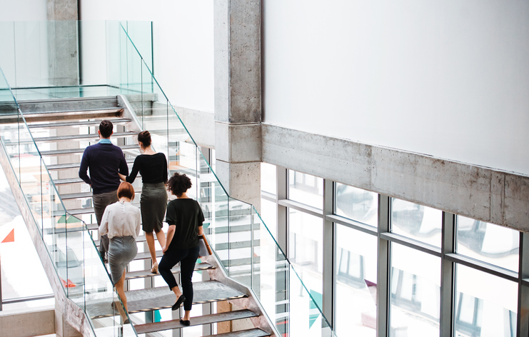 businesspeople walking up glass staircase