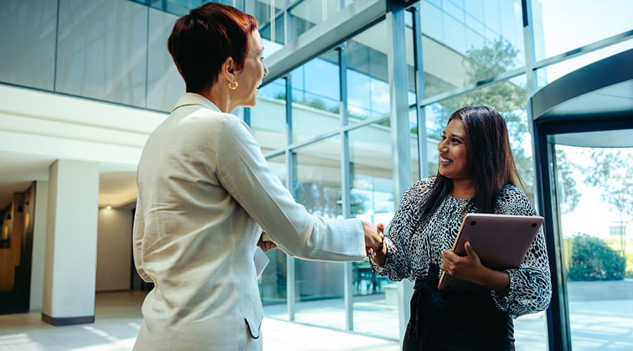 Professional-businesswomen-shaking-hands-in-a-bright-modern-office-lobby