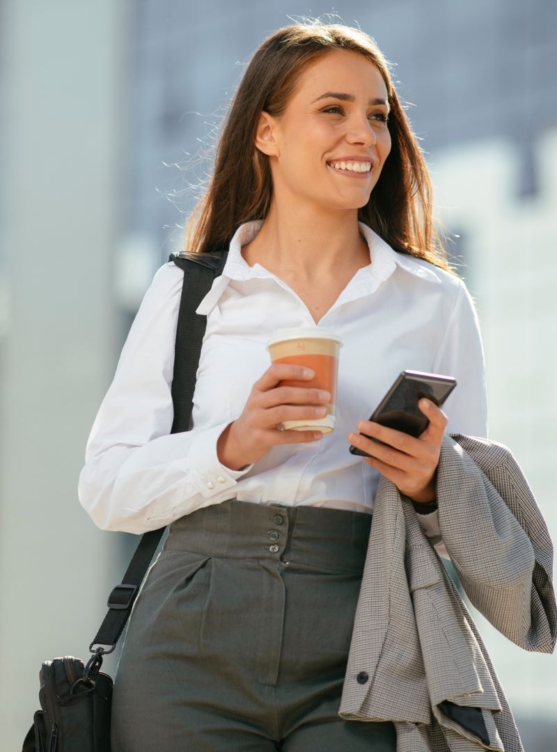 Une femme dans la rue sur le point de téléphoner à LHH Recruitment Solutions