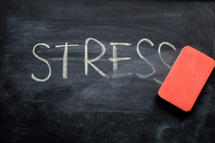 eraser erasing the word "stress" on a blackboard