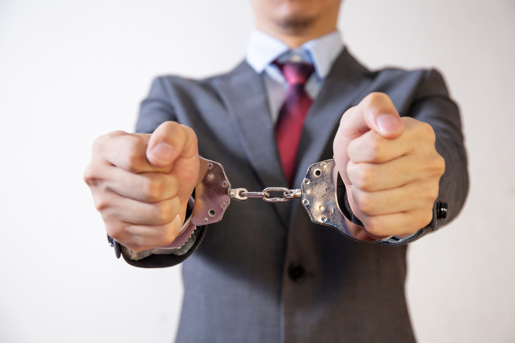 man in suit in handcuffs