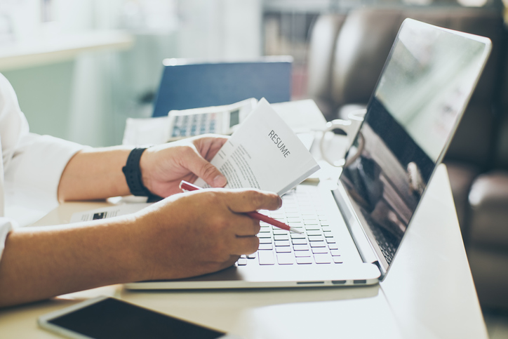 woman reading resume in front of open laptop