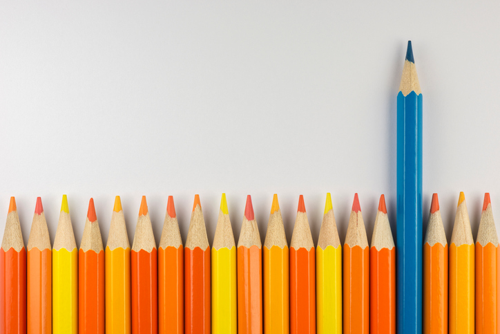 blue pencil standing out from the red, yellow and orange pencils