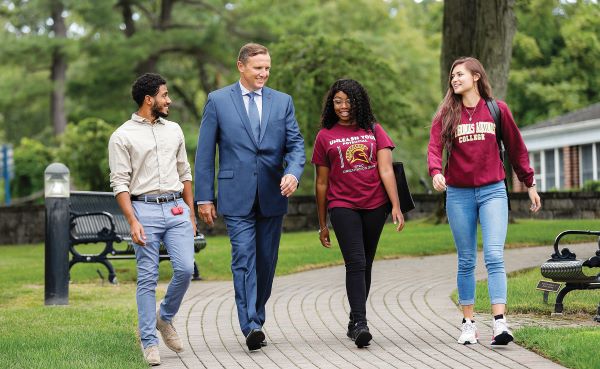 Ken Daly walking with students on campus