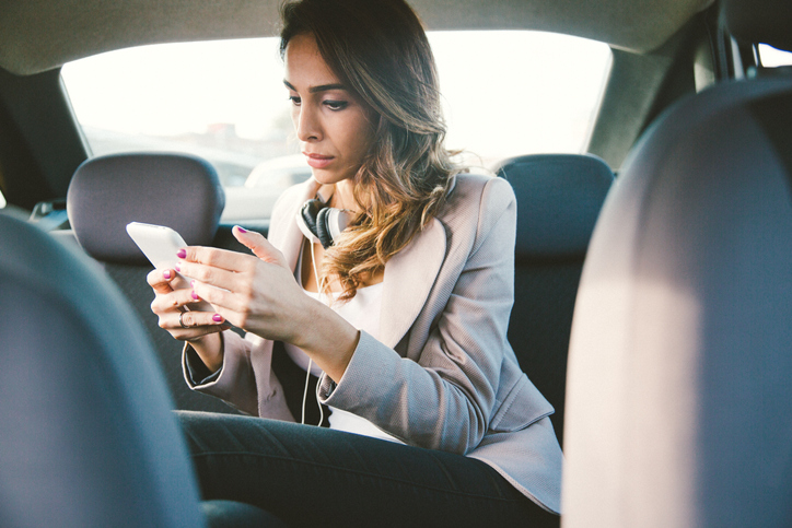 female executive in taxi on phone
